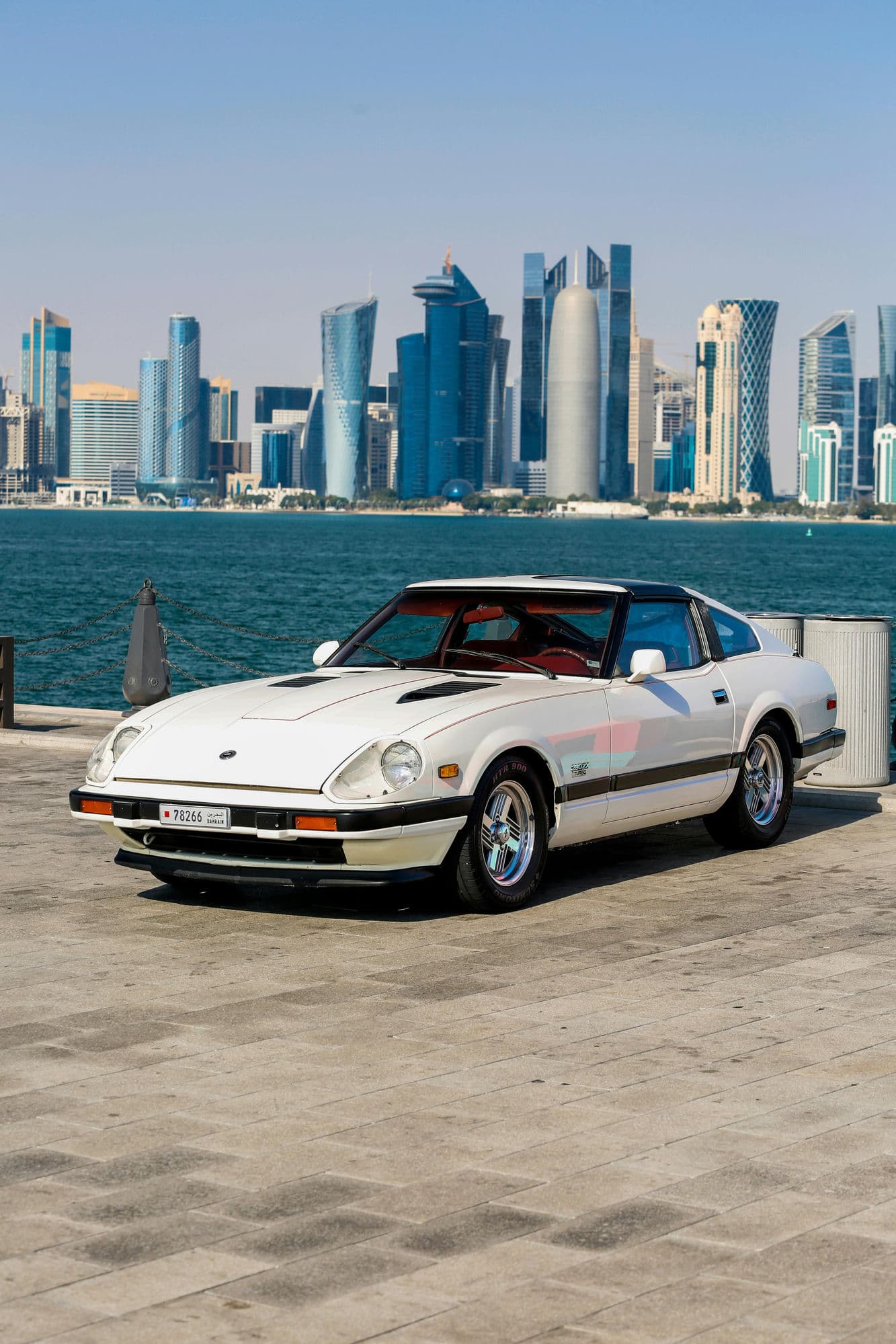 Classic car with Doha skyline